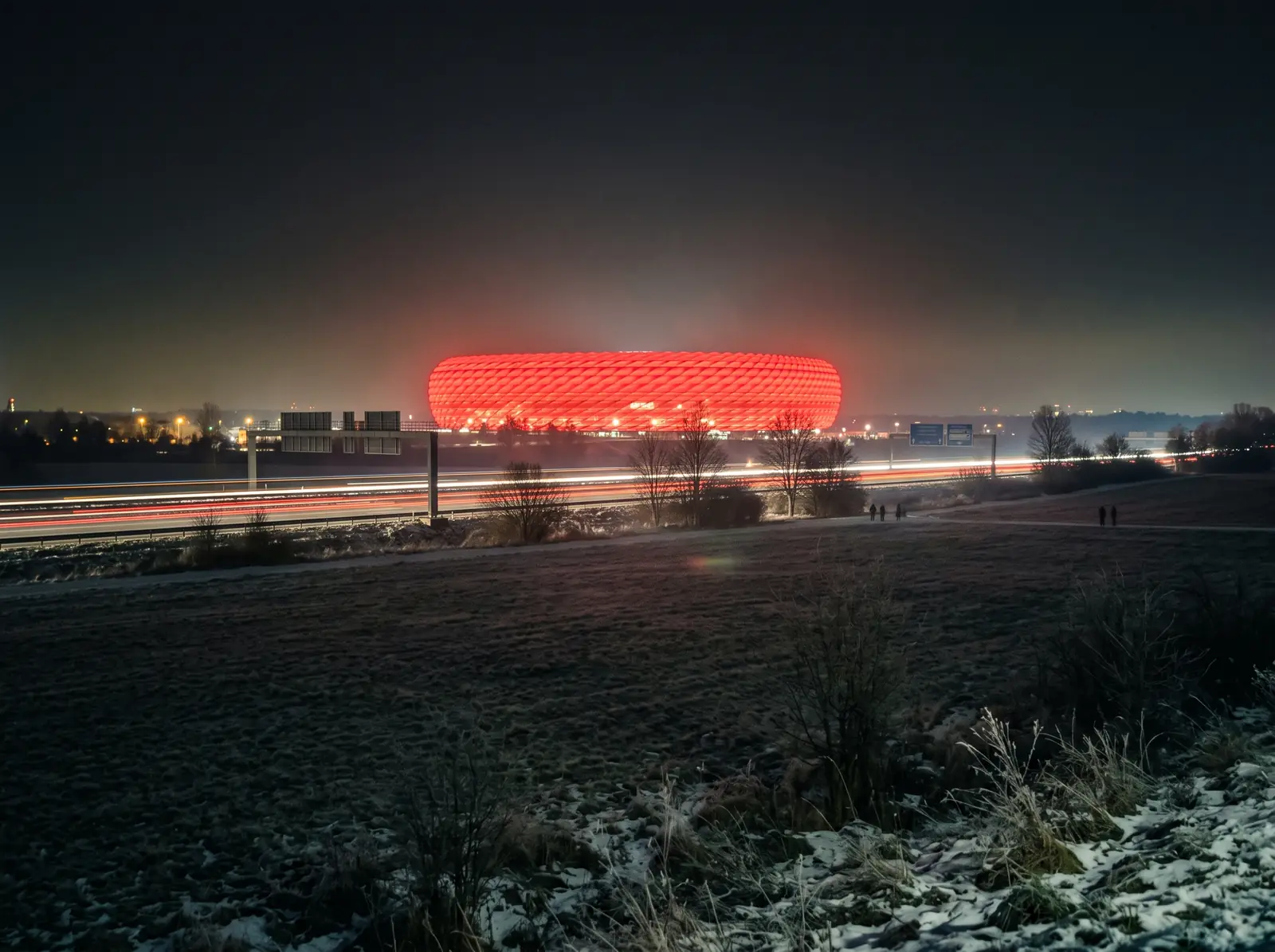 Allianz Arena lyser rött över fälten utanför München en frostig kväll