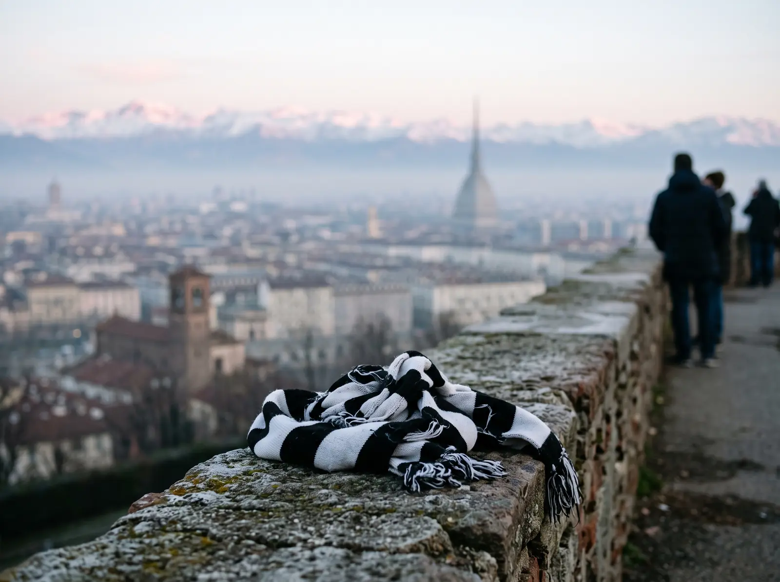 En halsduk i svart och vitt på en stenmur med Turin och Alperna i bakgrunden